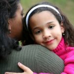 smiling girl hugging mother