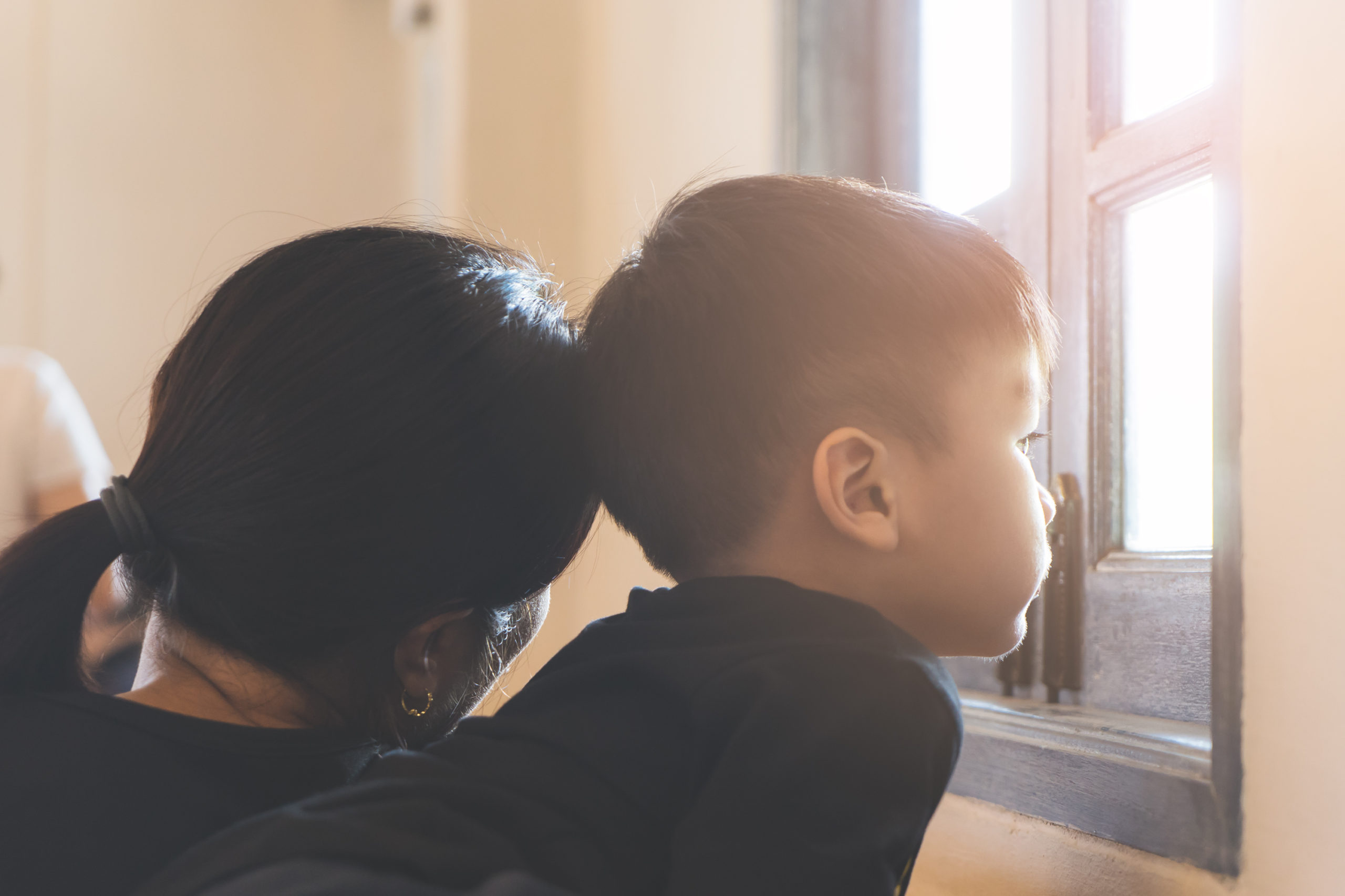 Mom and son looking out window